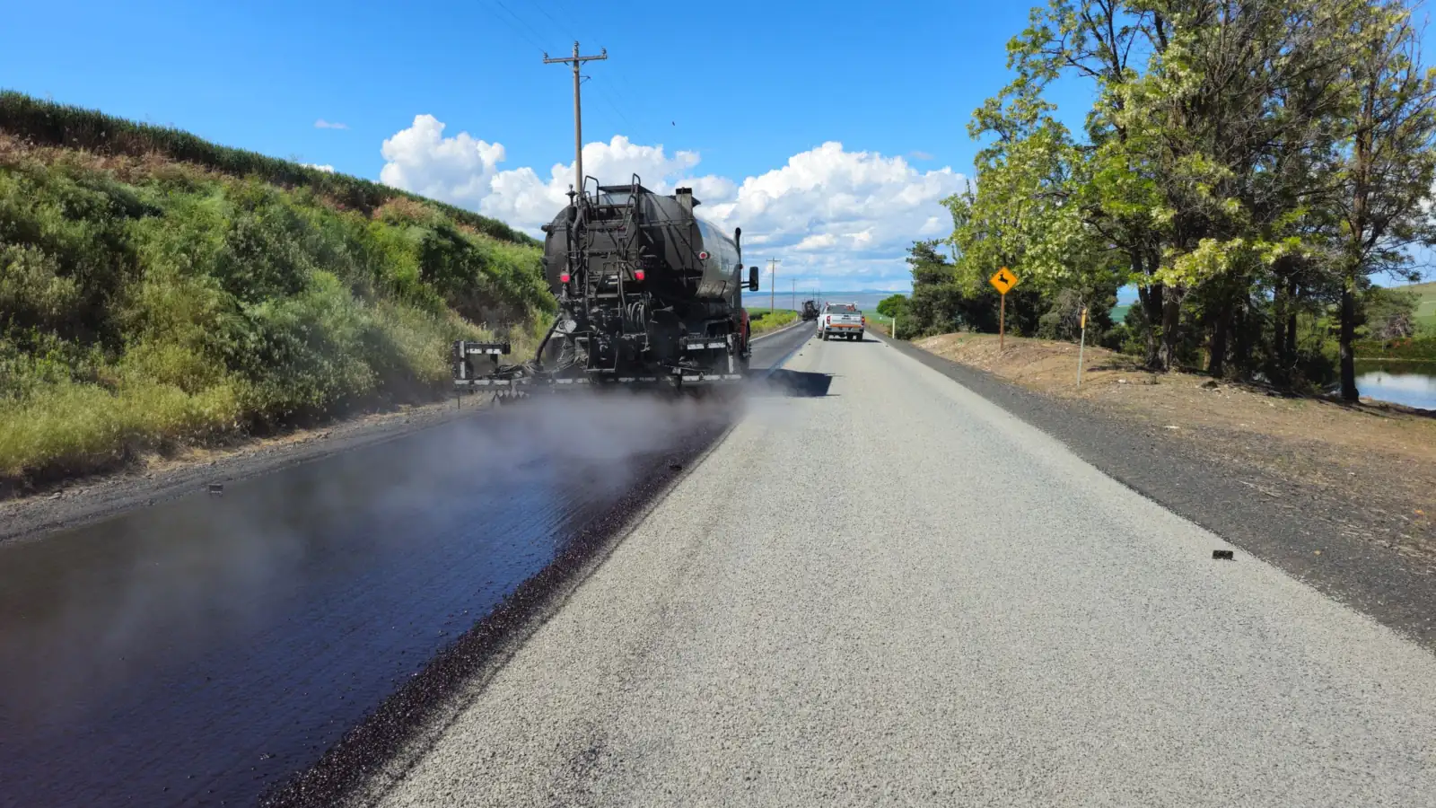Máquina vibroacabadora aplica asfalto em obra de rodovia