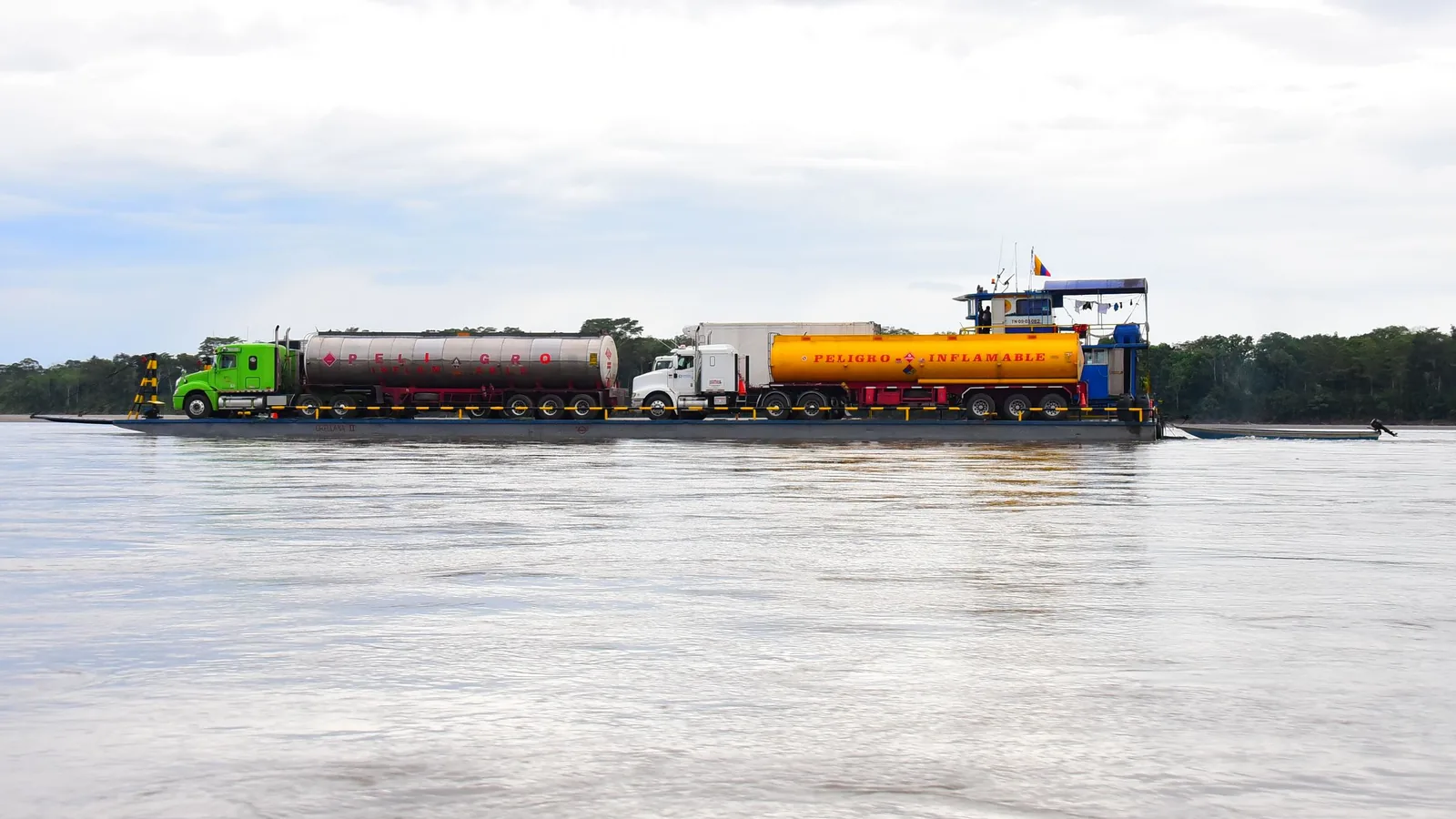 Caminhões-tanque transportados em balsa sobre rio