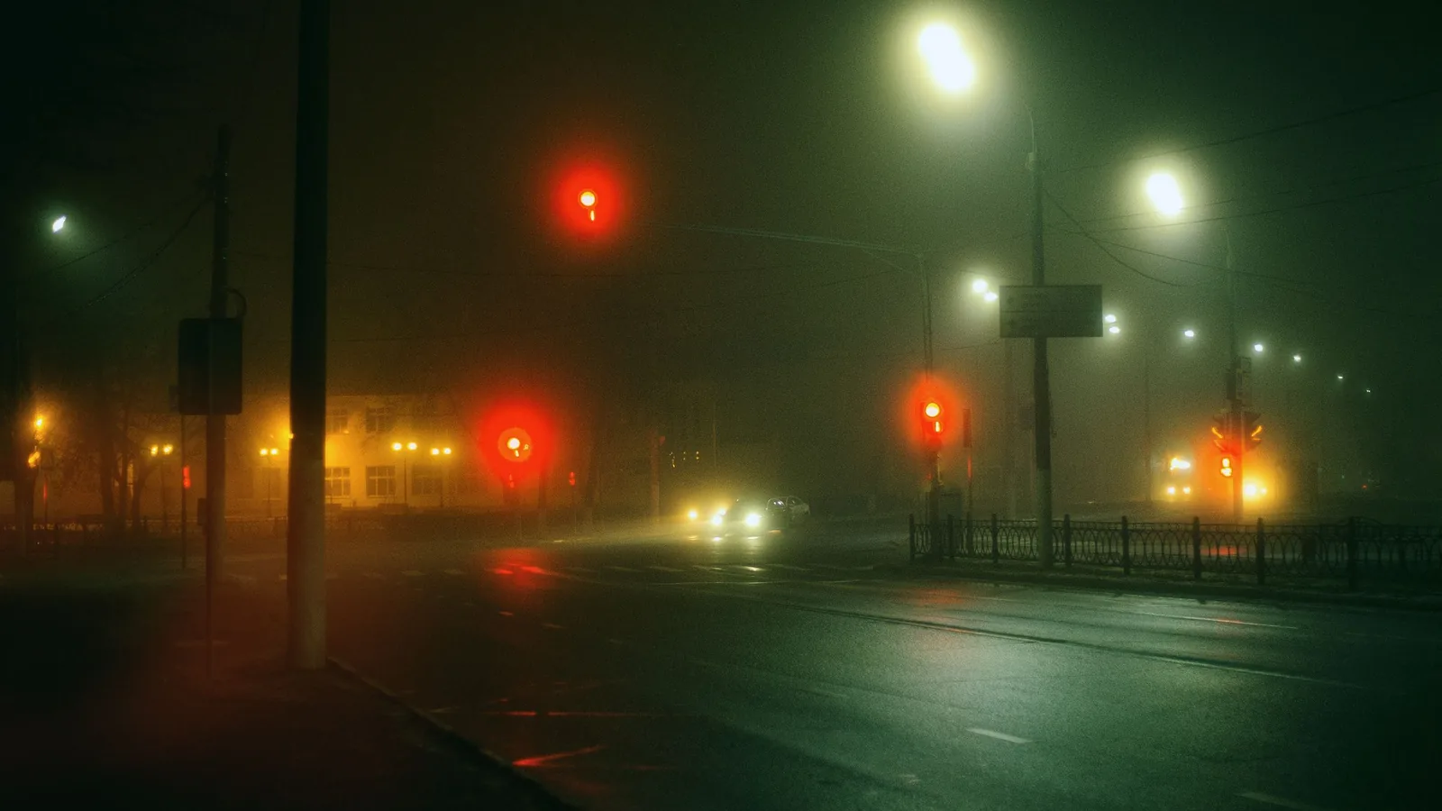 Semáforos acesos em via urbana à noite